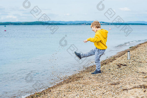 年轻的男孩<strong>扔石头</strong>海水
