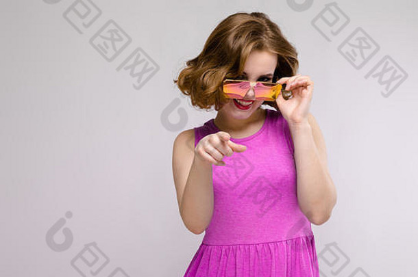 迷人的年轻的女孩粉红色的衣服灰色的背景快乐的女孩广场眼镜