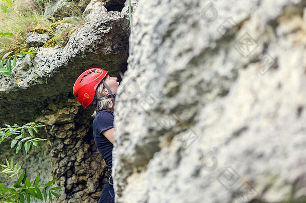 照片旅游女人红色的头盔攀爬岩石
