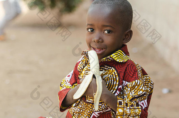 坦诚的拍摄非洲黑色的男孩吃香蕉户外