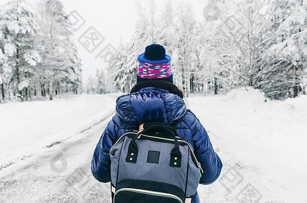 旅行生活方式年轻的女人背包冬天雪路瑞典