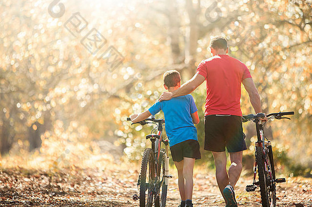 充满深情的父亲儿子走山自行车路径森林
