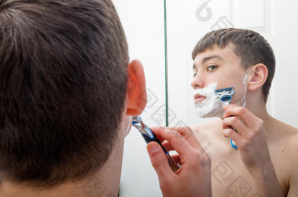 十几岁的男孩浴室镜子刮胡子早....