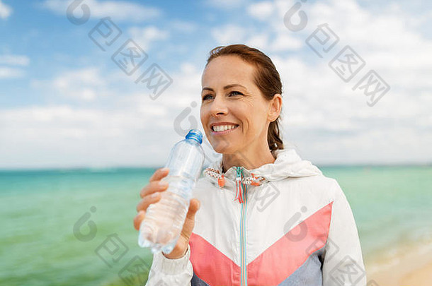 女人喝水锻炼海滩