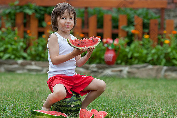 甜蜜的男孩吃西瓜花园夏季