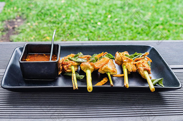 鸡烤姜黄包装柠檬草蔬菜草辣的酸酱汁泰国食物板杯黑色的花园