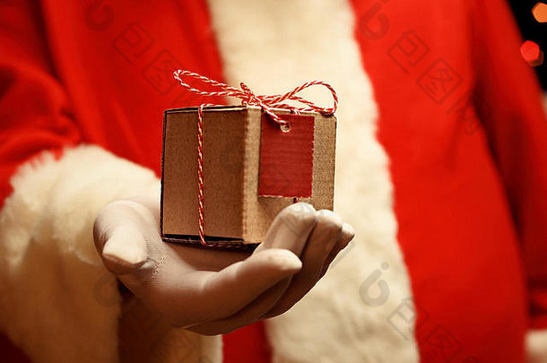 圣诞老人老人戴着手套手持有礼品盒