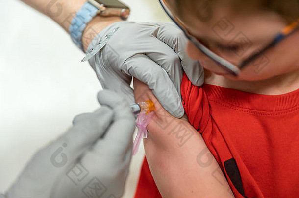 年轻的男孩看护士给疫苗手臂医疗概念