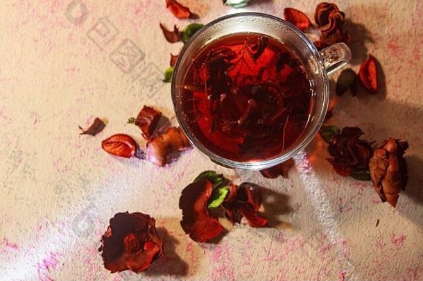 红色的热芙蓉茶玻璃杯子木表格玫瑰花瓣干茶蛋奶沙司carcade