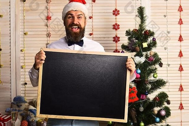 男人。胡子持有空白黑板上复制<strong>空间</strong>的家伙圣诞节树木墙背景圣诞老人老人红色的他快乐的脸黑板庆祝活动一年情绪概念