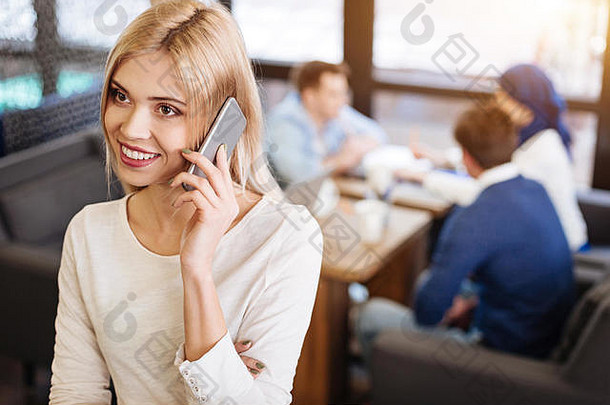 微笑美丽的女人会说话的电话咖啡馆