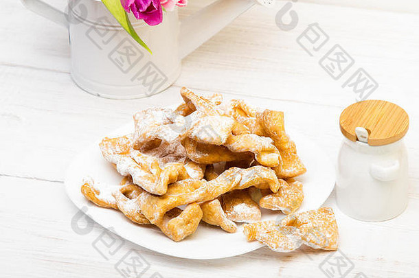faworki传统的波兰的饼干服务脂肪周四饼干郁金香花束白色木背景