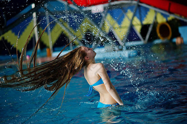 运动冻结美丽的年轻的女孩溅池水头发水公园