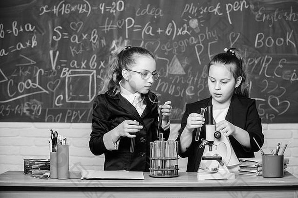 女孩同学们研究化学显微镜测试管表格执行化学反应基本知识化学使研究化学有趣的教育实验概念