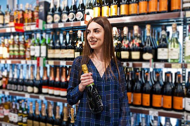 购物女人货架上超市肖像年轻的女孩市场商店酒精部门瓶香槟