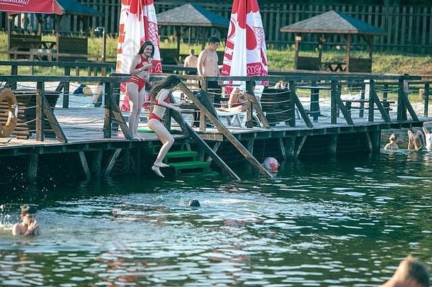 女孩跳码头湖水