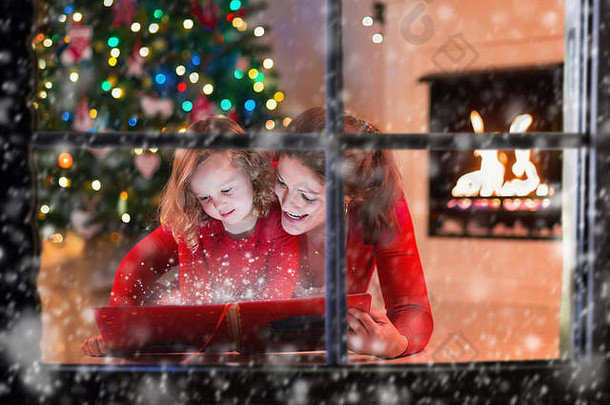 妈妈。女儿读书壁炉圣诞节夏娃家庭孩子庆祝圣诞节装饰生活房间