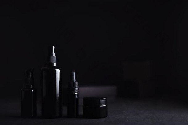 集无标号优雅的豪华的黑色的玻璃护肤品化妆包装黑色的不光滑的礼物盒子模糊软黑色的背景