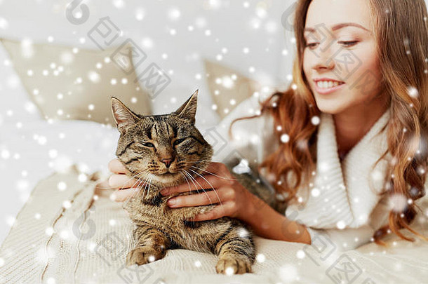 快乐年轻的女人猫说谎床上首页