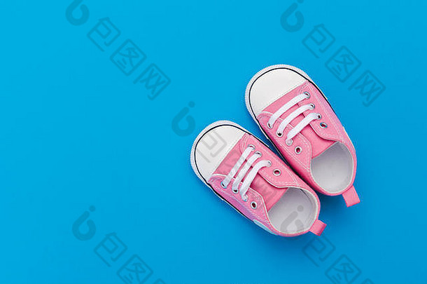 粉红色的婴儿鞋子蓝色的背景空间文本前视图