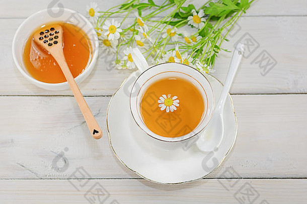 碗填满花蜂蜜勺子杯茶装饰洋甘菊