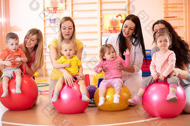 集团年轻的母亲婴儿瑜伽练习体操球健身健身房