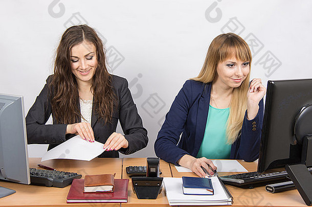 年轻的漂亮的业务女人坐着办公室表格划分工作