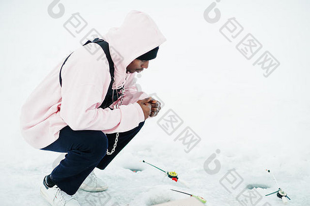 非洲美国渔夫钓鱼杆坐着冻海冬天钓鱼