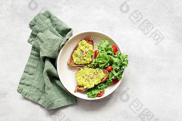 素食者素食主义者鳄梨烤面包种子甘蓝番茄沙拉服务板灰色混凝土背景表格前视图拍摄健康的食物