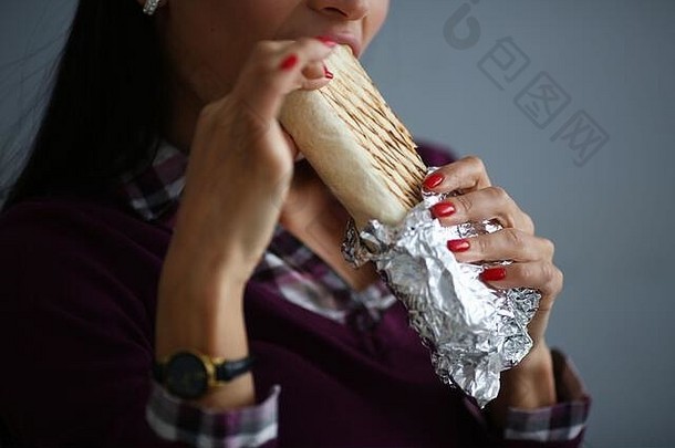女人吃美味的shawarma丝带面包箔