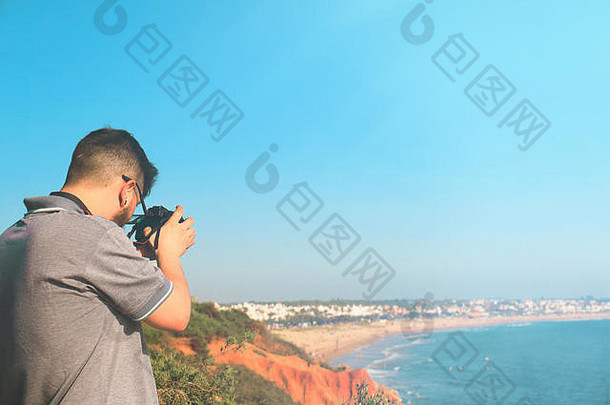 年轻的摄影师使照片海景相机