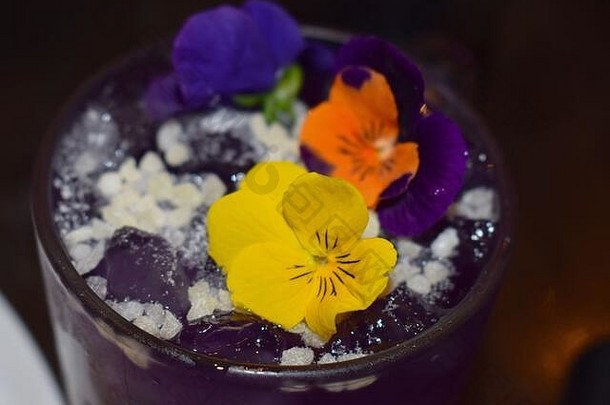 柠檬伏特加鸡尾酒装饰三色紫罗兰笑脸脸同时sip花俏的植物含酒精的喝服务苏荷区