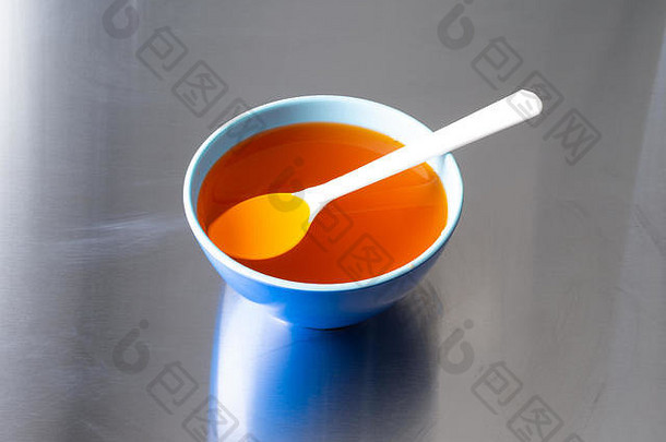蓝色的碗橙色味道明胶白色勺子浮动食物不锈钢钢计数器前