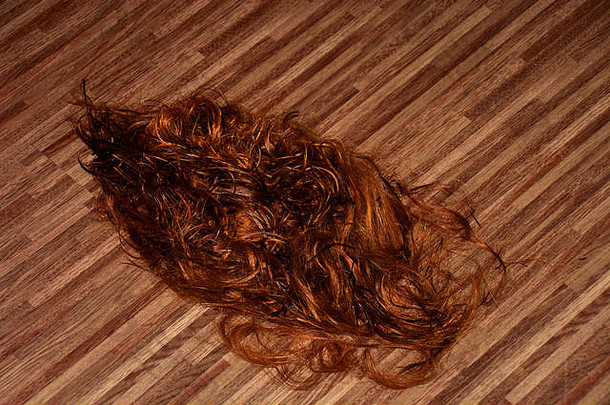 减少长红色的头发地板上美容沙龙红色的把头发美沙龙