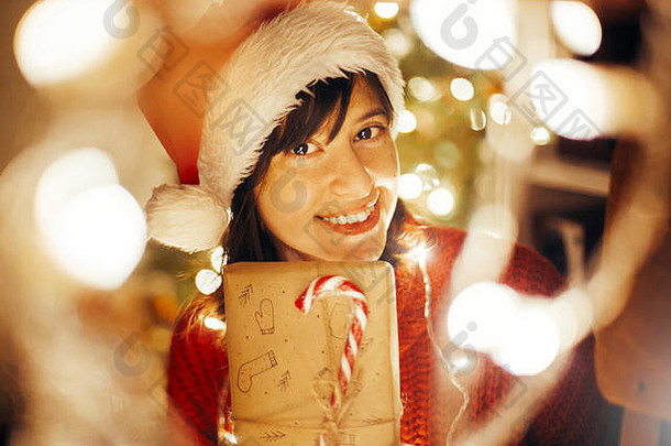 快乐女孩圣诞老人他红色的毛衣包装圣诞节礼物灯晚上节日房间树照明开放现代工艺礼物