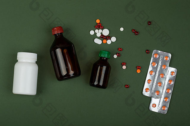 医学概念色彩斑斓的药片医疗瓶绿色纸背景