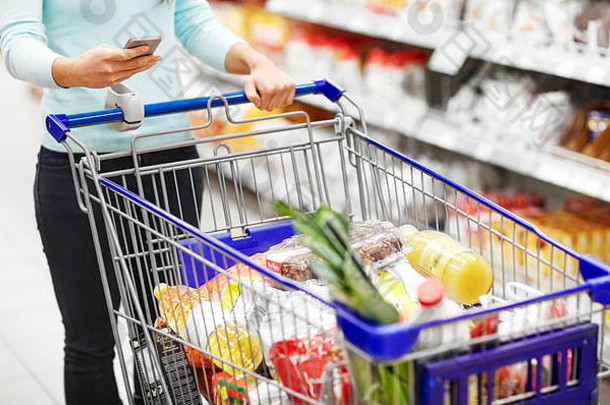 女人智能手机购买食物超市