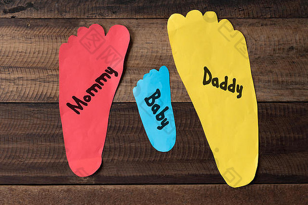 家庭测量脚色彩斑斓的纸木背景家庭概念脚形状纸写妈妈爸爸婴儿