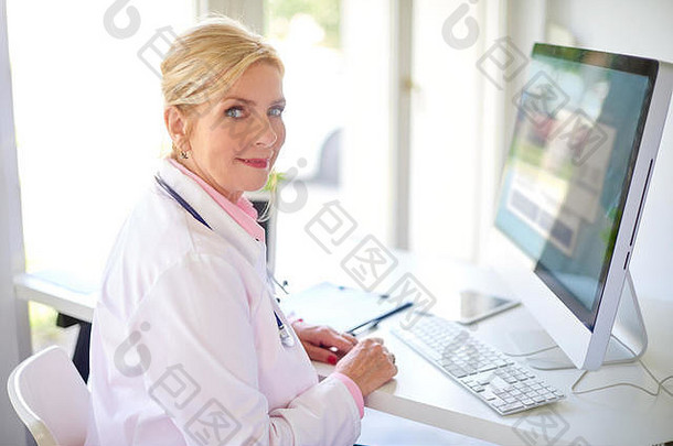 微笑高级女研究医生电脑移动PC工作桌子上