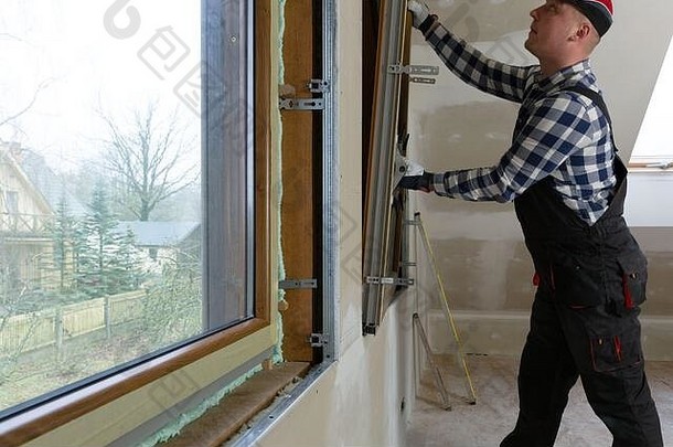 杂工建设男人。安装聚氯乙烯窗口绝缘填满干墙阁楼