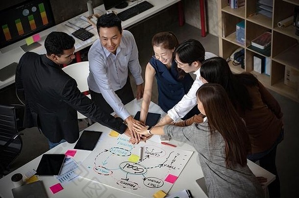 集团亚洲团队有创意的业务人加入手伙伴关系团队合作概念