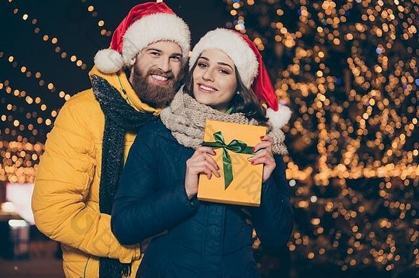 快乐照片人夫妇丈夫的家伙兴奋妻子夫人持有x-mas礼品盒传统穿外套圣诞老人帽围巾newyear公园