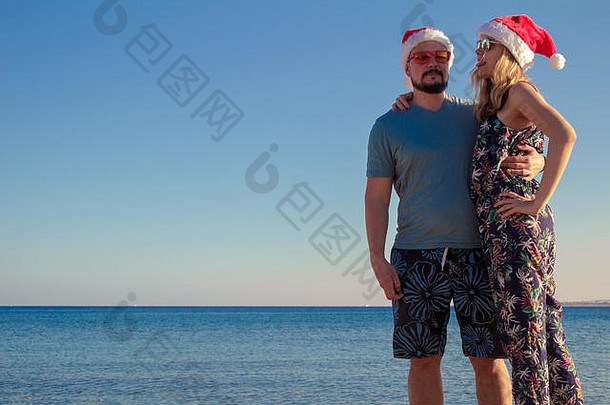 男人。女人拥抱圣诞节帽子太阳镜海滩海