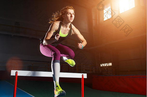 年轻的女运动员运行跳障碍冲刺比赛障碍体育运动培训概念背景