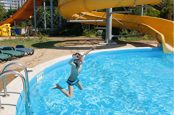 薄高加索人女孩跳蓝色的池水公园酒店夏天假期