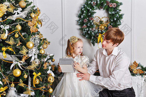 父亲女儿圣诞节树隐藏礼物概念庆祝活动有趣的家庭幸福童年