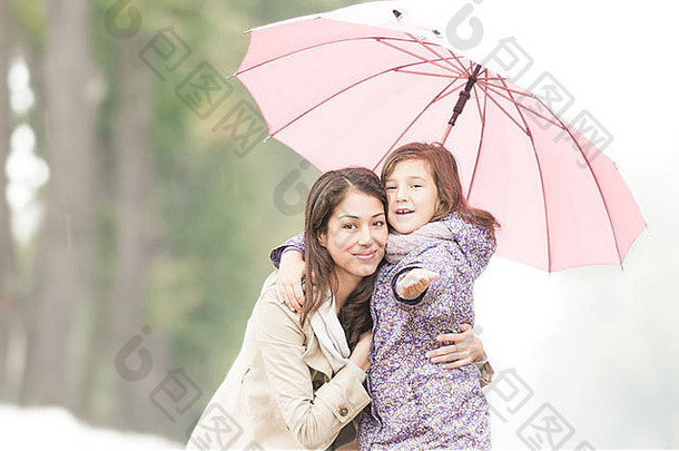 年轻的美丽的女人漂亮的女儿公园伞妈妈。女儿友好的家庭
