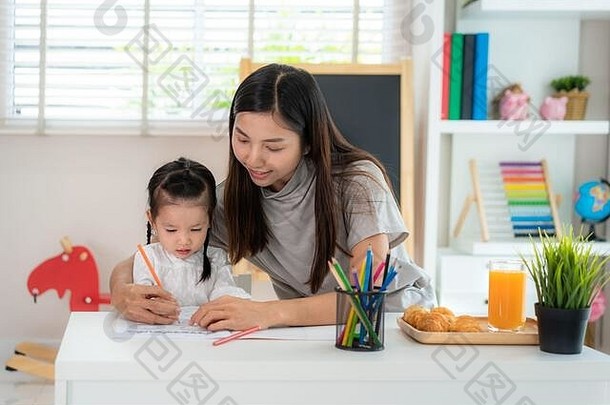 亚洲幼儿园学生女孩妈妈。绘画图片书颜色铅笔首页在家教育距离学习