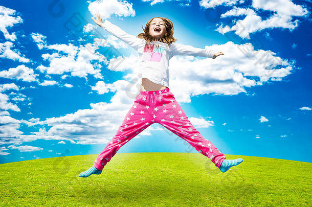 快乐女孩跳高绿色草阳光明媚的一天