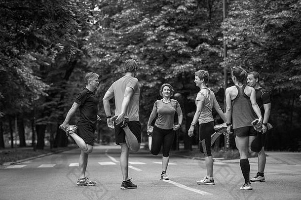 健康的跑步者团队气候变暖伸展运动城市公园早....培训